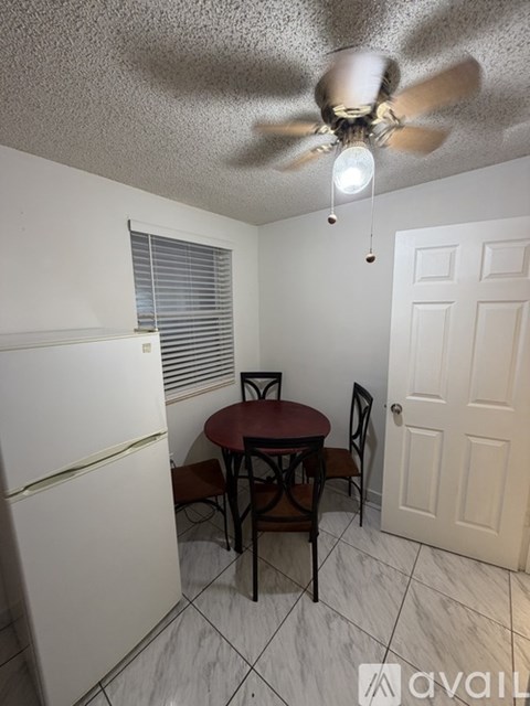 A small dining area with a table and chairs.