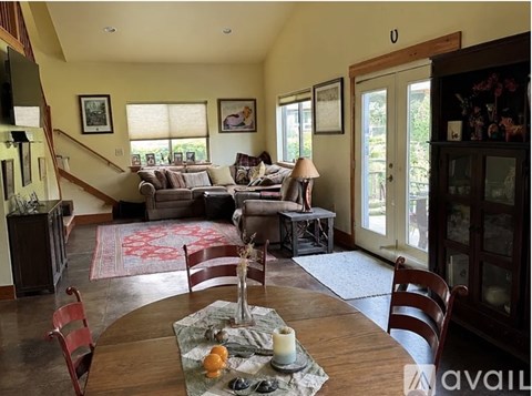A dining room with a wooden table and chairs.