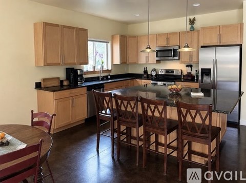 A kitchen with wooden chairs and a table.