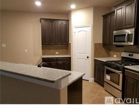 A kitchen with brown cabinets and a white door.