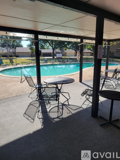 A poolside area with chairs and tables is available for use.