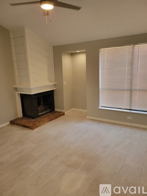 A living room with a fireplace and a fan.