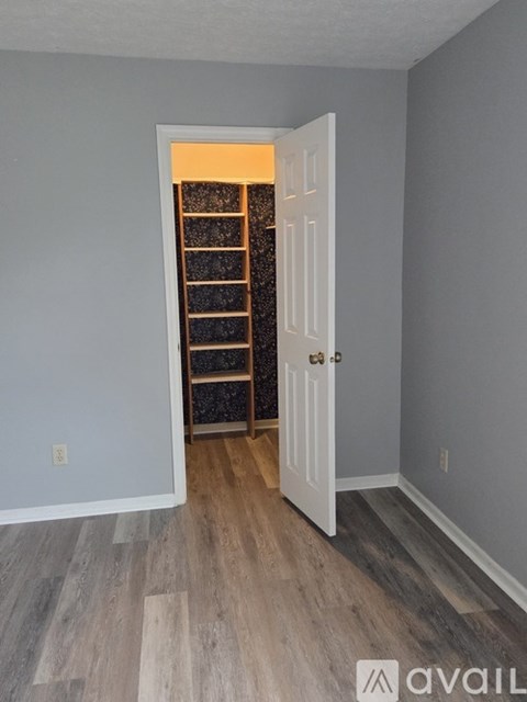 A room with a white door and a wine rack in the background.
