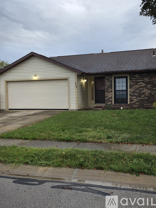 A house with a garage door and a brick wall.