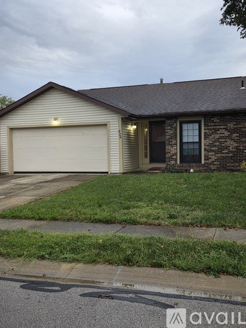 A house with a garage door and a brick wall.