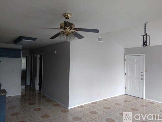 A room with a ceiling fan and a door.