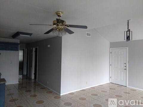 A room with a ceiling fan and a door.