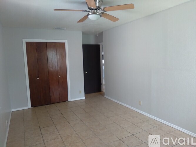 A room with a ceiling fan and a door.