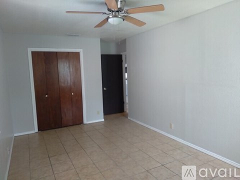 A room with a ceiling fan and a door.