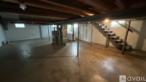 A spacious room with a staircase and a refrigerator.