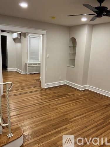 A room with wooden floors and a ceiling fan.