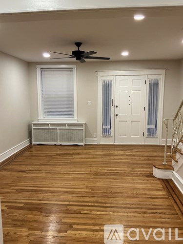 A room with wooden floors and a ceiling fan.
