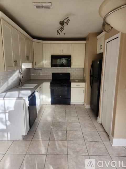 A kitchen with white appliances and beige cabinets.