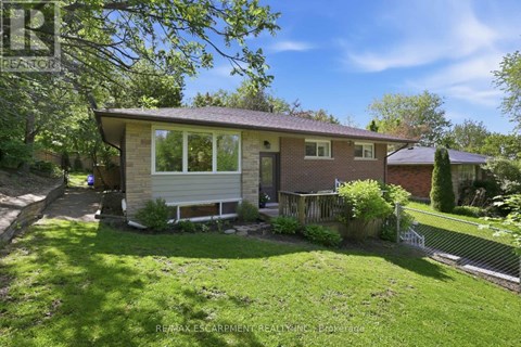 A house with a well-kept lawn and trees in the background.