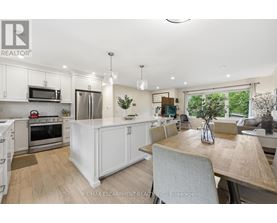 A modern kitchen with white cabinets and a wooden table.