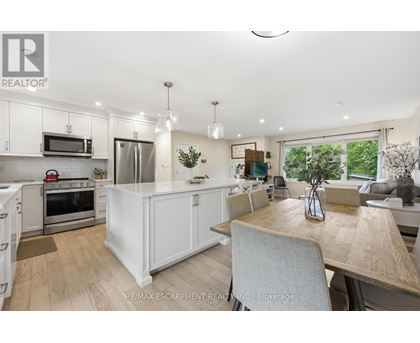 A modern kitchen with white cabinets and a wooden table.