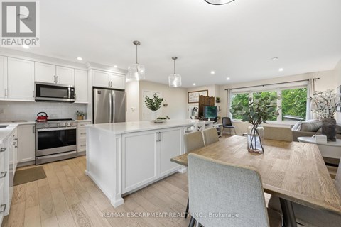 A modern kitchen with white cabinets and a wooden table.