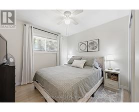 A bedroom with a bed, nightstand, and a ceiling fan.
