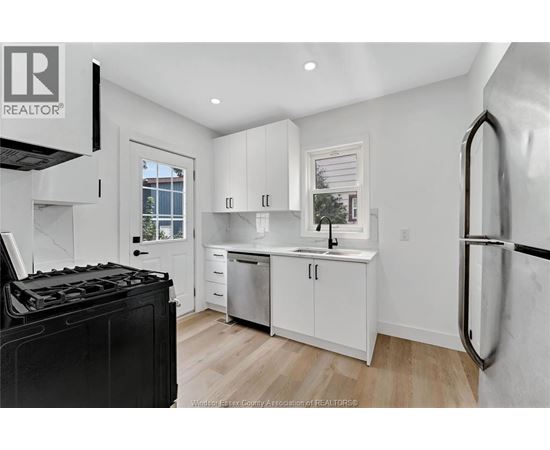 A kitchen with white cabinets and a black stove top.