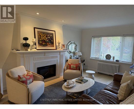A living room with a fireplace and a painting above it.