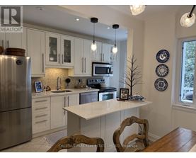 A kitchen with a refrigerator, microwave, and oven.