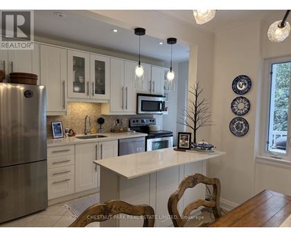 A kitchen with a refrigerator, microwave, and oven.