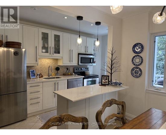 A kitchen with a refrigerator, microwave, and oven.