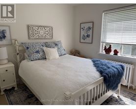 A white bed with a blue throw blanket and matching pillow cases.