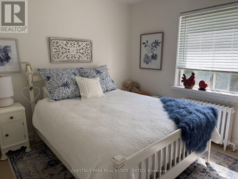 A white bed with a blue throw blanket and matching pillow cases.