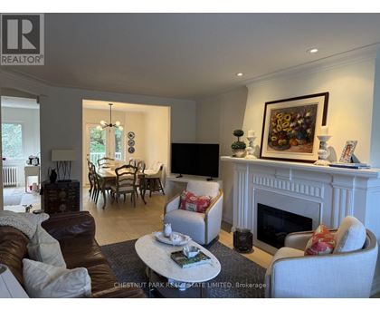 A living room with a fireplace and a painting on the wall.
