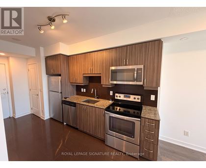 A modern kitchen with wooden cabinets and stainless steel appliances.