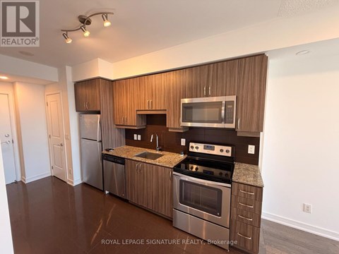 A modern kitchen with wooden cabinets and stainless steel appliances.