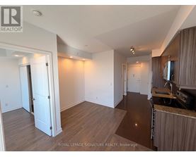A well-lit, spacious room with wooden flooring and white walls.
