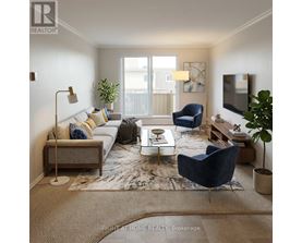 A living room with a grey sofa, a blue armchair, a white coffee table, and a large window.