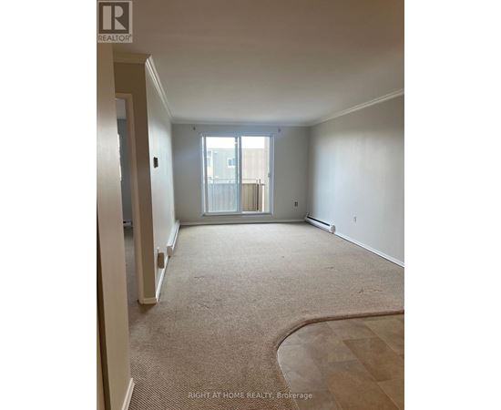 A room with a carpeted floor and a door leading to a balcony.