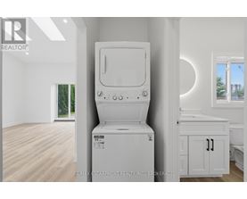 A white washing machine in a room with wooden flooring.