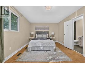 A bedroom with a large bed and a rug on the floor.