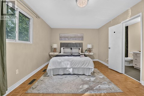 A bedroom with a large bed and a rug on the floor.