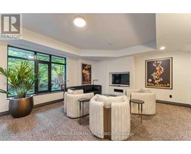 A living room with a large sofa, a chair, and a potted plant.