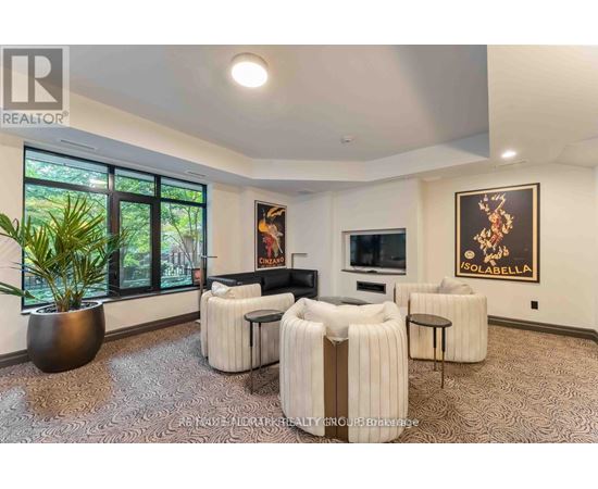 A living room with a large sofa, a chair, and a potted plant.