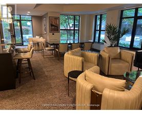A room with beige chairs and a carpet with a pattern.