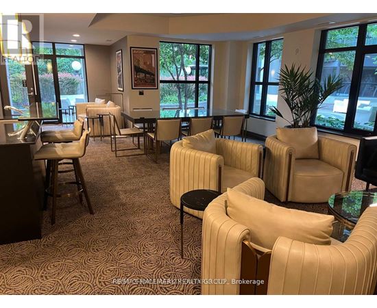 A room with beige chairs and a carpet with a pattern.