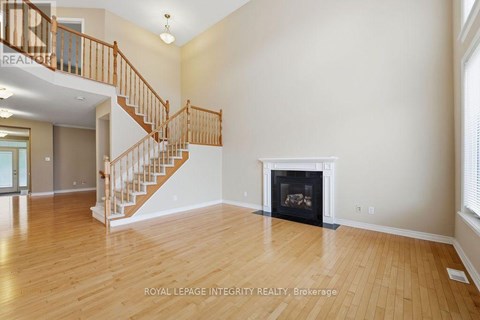 A spacious living room with a fireplace and a staircase.