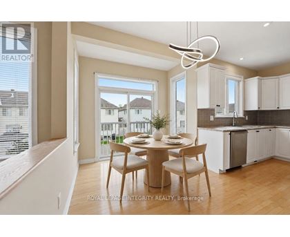 A dining area with a table set for two and a kitchen in the background.