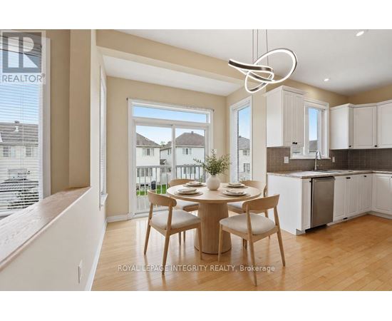 A dining area with a table set for two and a kitchen in the background.