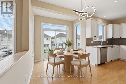A dining area with a table set for two and a kitchen in the background.