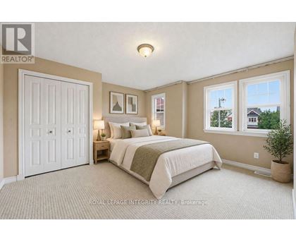 A bedroom with a large bed and a window overlooking a street.