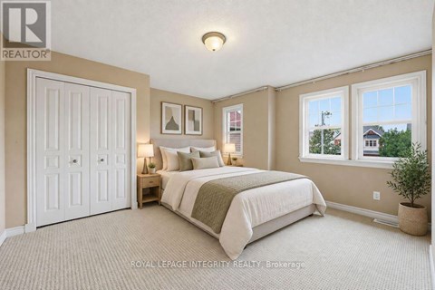 A bedroom with a large bed and a window overlooking a street.