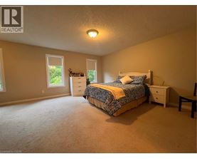 A bedroom with a bed, nightstand, and window.
