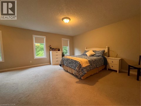 A bedroom with a bed, nightstand, and window.